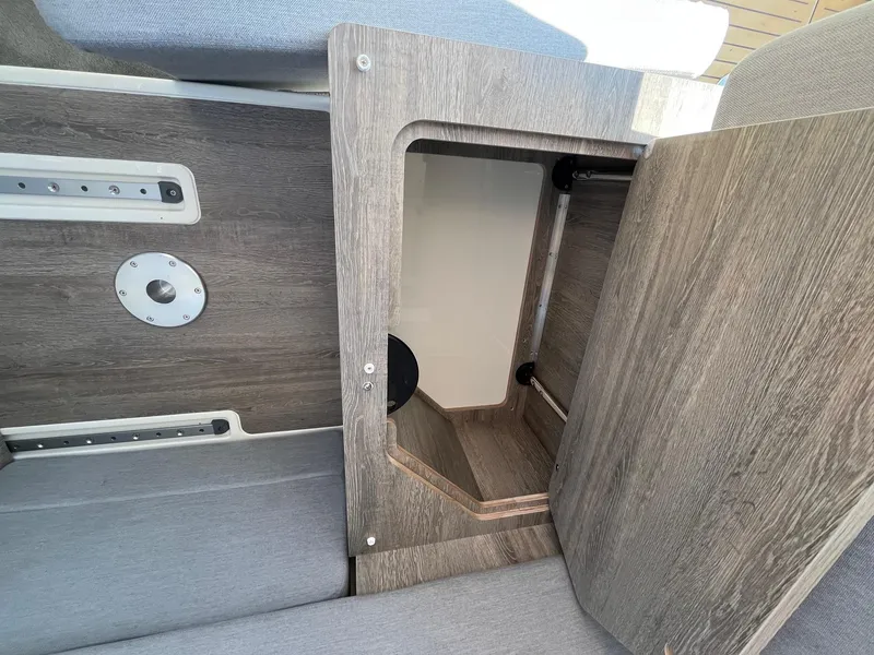 Slide: The Image of 2025 Bayliner Trophy T29 Explorer interior storage compartment with wood finish. - 13