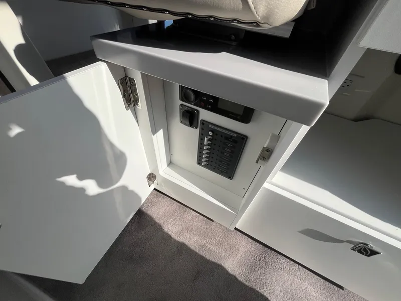 Slide: The Image of 2025 Bayliner Trophy T29 Explorer interior cabinet with control panel and open door. - 14