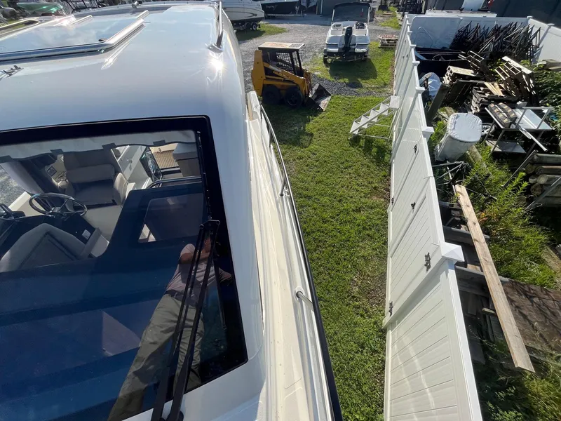 Slide: The Image of 2025 Bayliner Trophy T29 Explorer boat parked near a fence, viewed from above. - 26