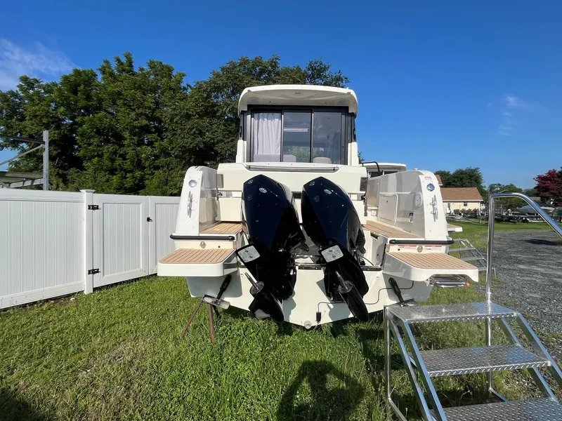 Slide: The Image of 2025 Bayliner Trophy T29 Explorer boat with dual outboard engines, parked on grass. - 3