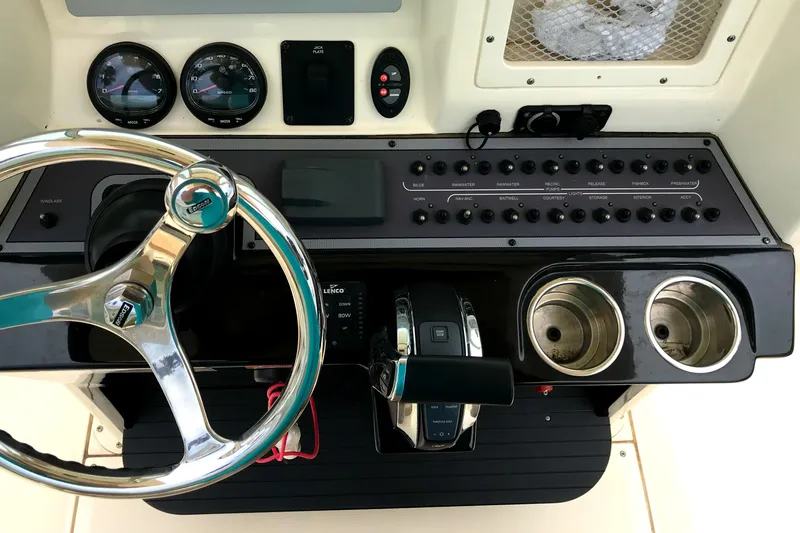 Slide: The Image of 2018 Scout 251 XSS boat dashboard with steering wheel and control panel. - 19