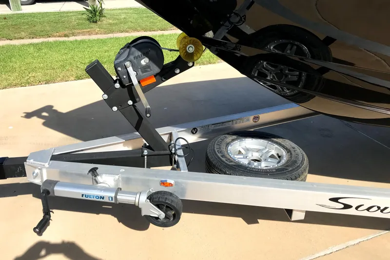 Slide: The Image of 2018 Scout 251 XSS boat trailer with winch and spare tire on pavement. - 3