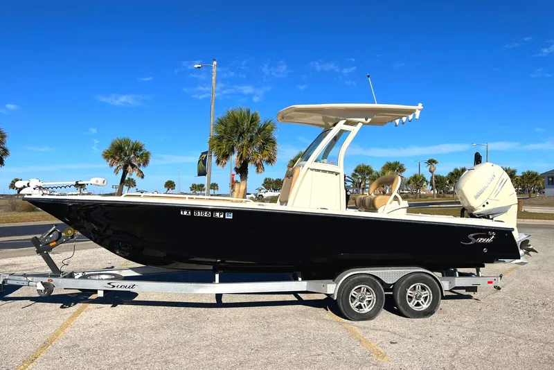 Slide: The Image of 2018 Scout 251 XSS boat on trailer, parked in sunny lot with palm trees. - 4