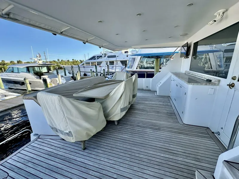 Slide: The Image of Spacious deck of 2001 Dovercraft Custom RPH yacht, featuring covered seating and docked at a marina. - 31