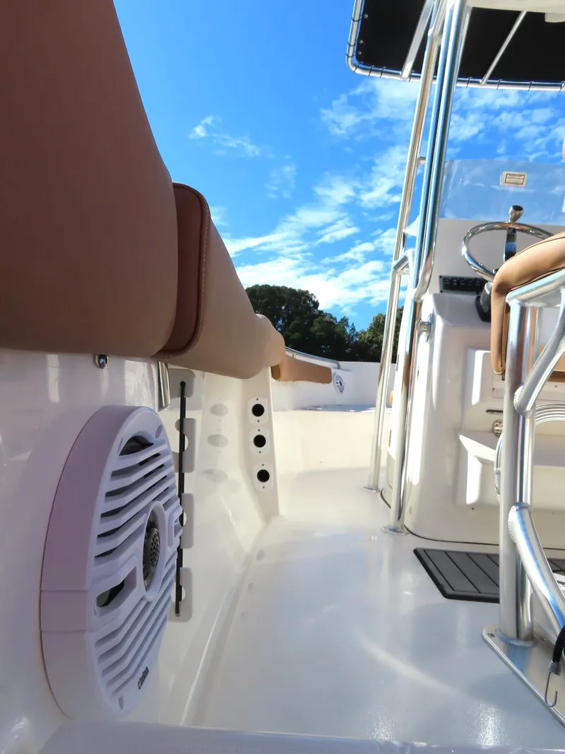 Slide: The Image of 2025 Key West 203 FS boat interior with seating and steering console under a clear blue sky. - 4