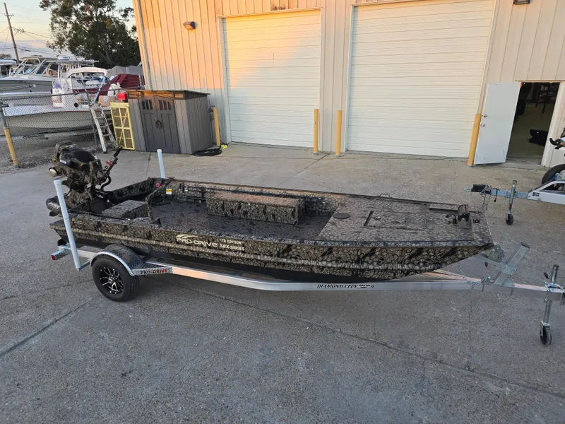Slide: The Image of 2025 Pro-Drive SBX Series TD boat on trailer, parked outside a building. - 2