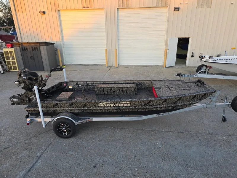 Slide: The Image of 2025 Pro-Drive SBX Series TD boat on trailer, parked outside a garage. - 3