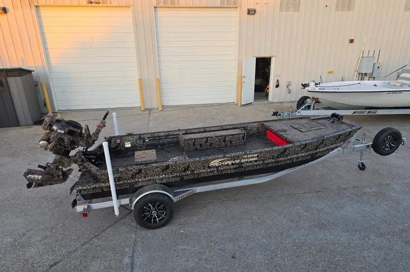Slide: The Image of 2025 Pro-Drive SBX Series TD boat on trailer, parked outside a garage. - 4