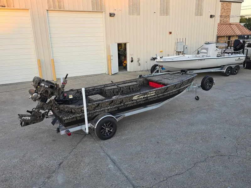 Slide: The Image of 2025 Pro-Drive SBX Series TD boat on trailer, parked outside a warehouse. - 6