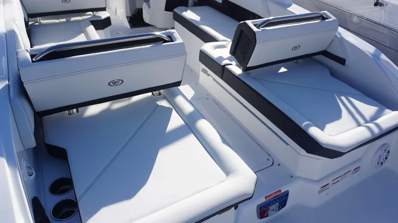 Slide: The Image of 2025 Cobalt R6 boat interior with white cushioned seating and cup holders. - 13