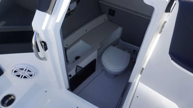 Slide: The Image of 2025 Cobalt R6 boat interior with compact marine toilet and storage area. - 17