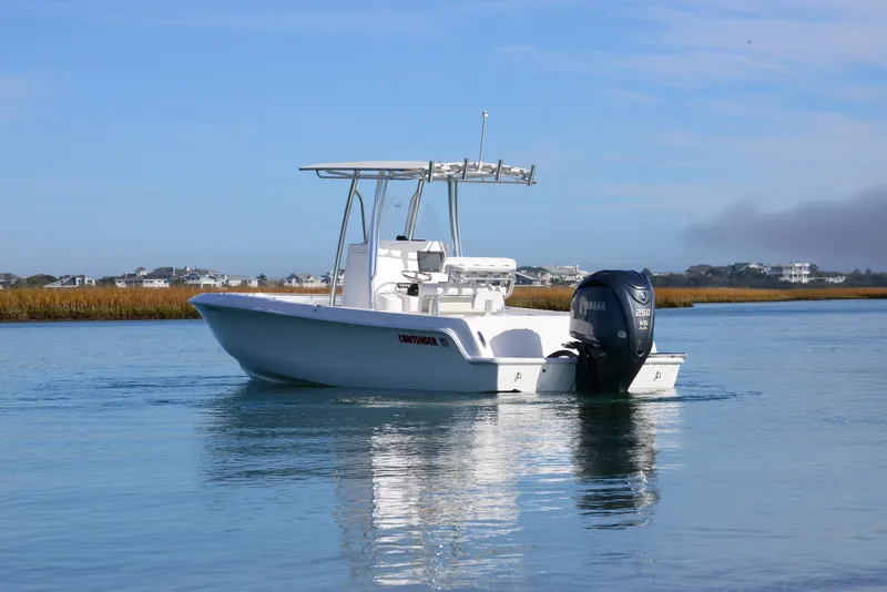 Slide: The Image of 2024 Contender 24 Sport boat on calm water with Yamaha outboard motor. - 11