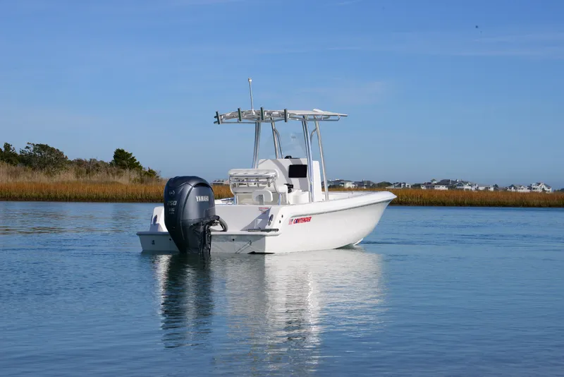Slide: The Image of 2024 Contender 24 Sport boat on calm water with Yamaha outboard motor. - 13