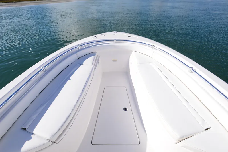 Slide: The Image of 2024 Contender 24 Sport boat bow with seating, on calm water. - 15