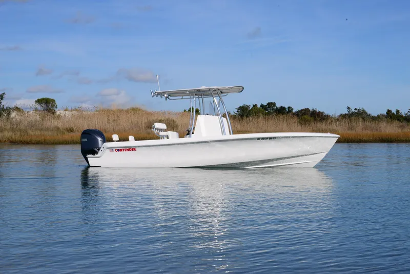Slide: The Image of 2024 Contender 24 Sport boat on calm water, side view. - 2