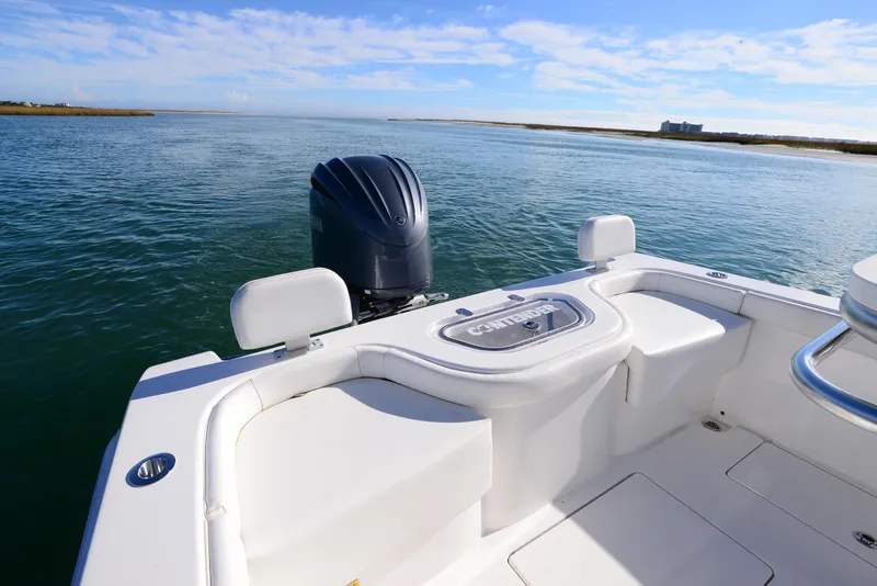 Slide: The Image of 2024 Contender 24 Sport boat on water, featuring sleek design and powerful outboard motor. - 23