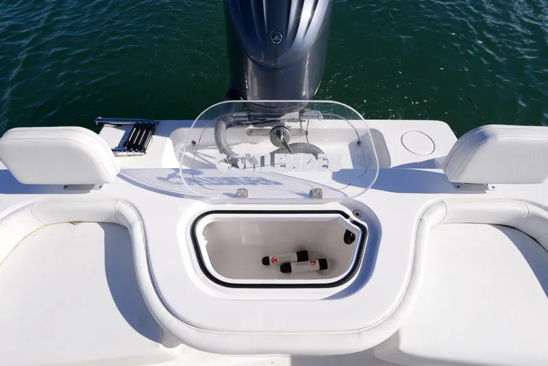 Slide: The Image of 2024 Contender 24 Sport boat with open storage compartment and seating. - 25
