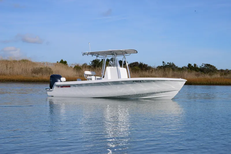 Slide: The Image of 2024 Contender 24 Sport boat on calm water, clear sky background. - 3