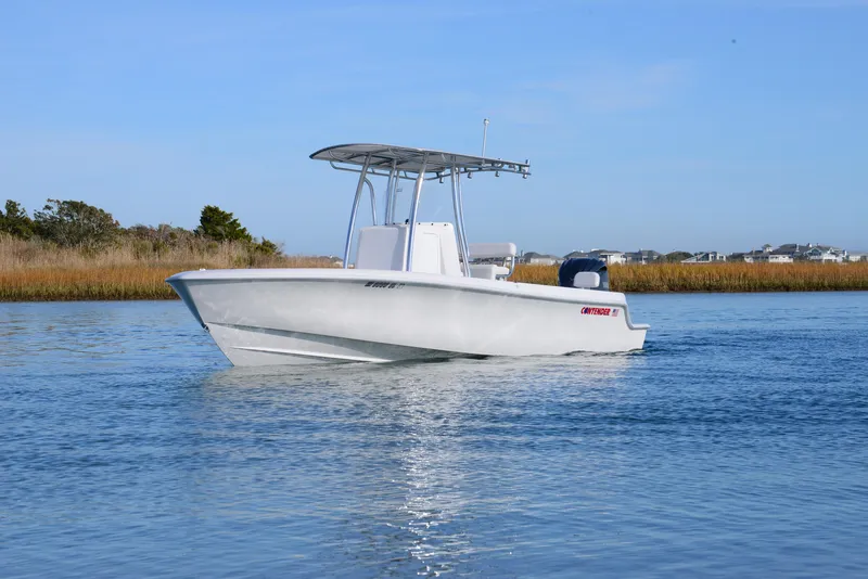 Slide: The Image of 2024 Contender 24 Sport boat on calm water, clear sky background. - 6