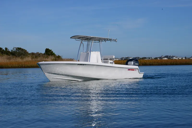 Slide: The Image of 2024 Contender 24 Sport boat cruising on calm water. - 7