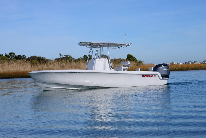 Slide: The Image of 2024 Contender 24 Sport boat cruising on calm water. - 8