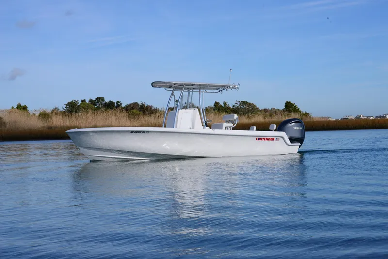 Slide: The Image of 2024 Contender 24 Sport boat cruising on calm water. - 9