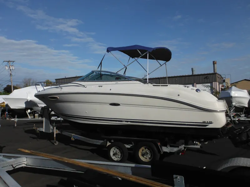 The Image of 2004 Sea Ray 215 Weekender boat on trailer with blue canopy. - 0