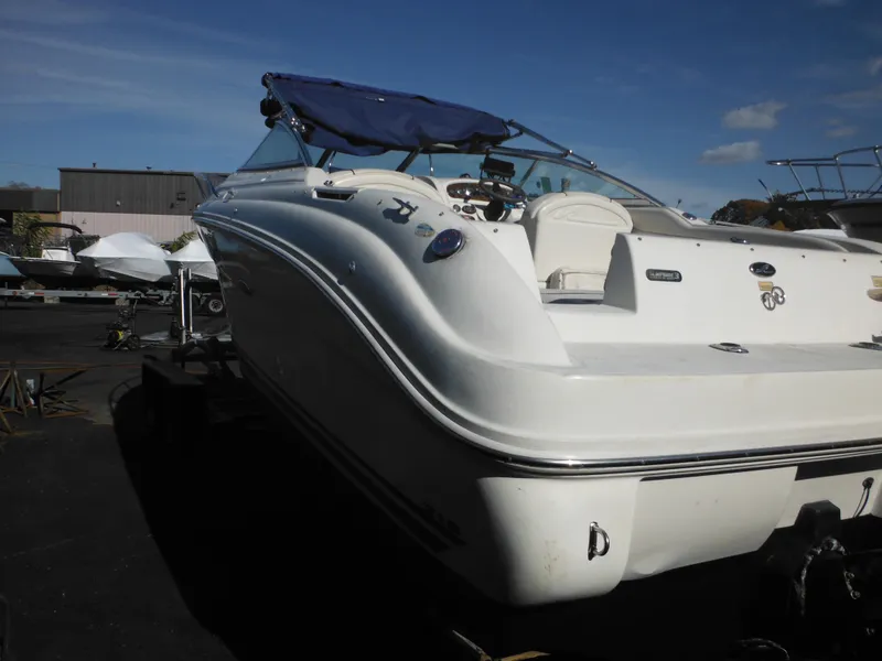 Slide: The Image of 2004 Sea Ray 215 Weekender boat with blue canopy in a marina setting. - 12