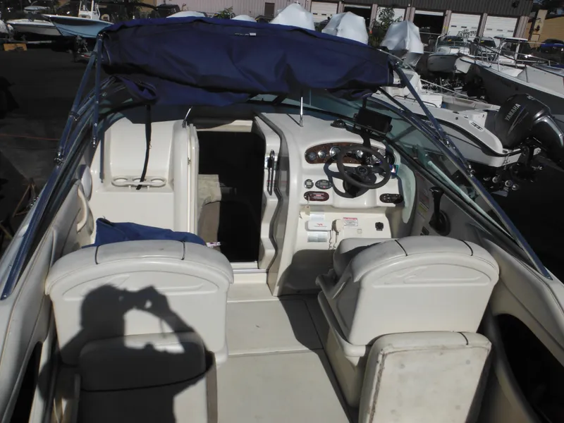 Slide: The Image of 2004 Sea Ray 215 Weekender boat interior with seating and steering wheel. - 13