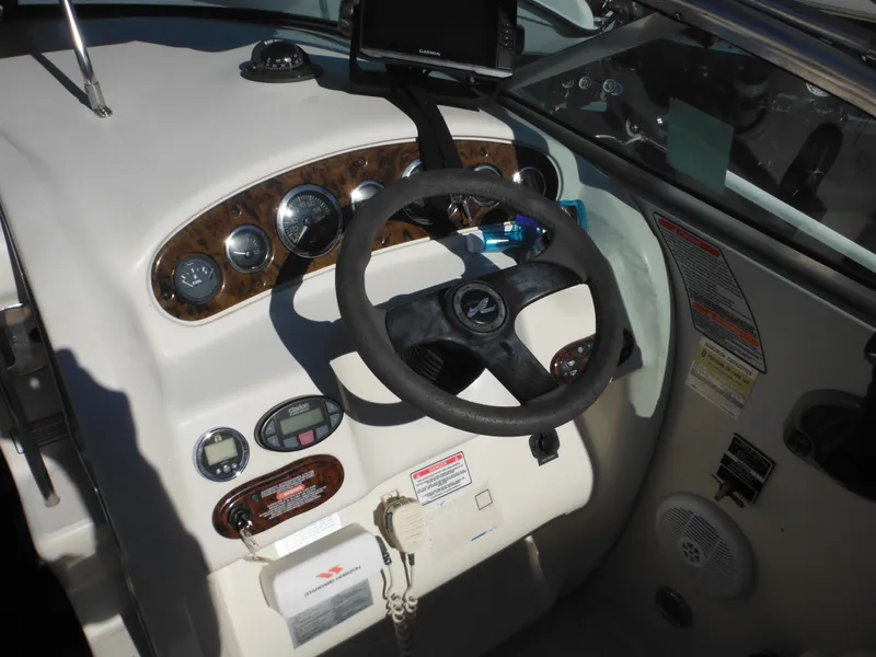 Slide: The Image of 2004 Sea Ray 215 Weekender boat dashboard with steering wheel and gauges. - 14