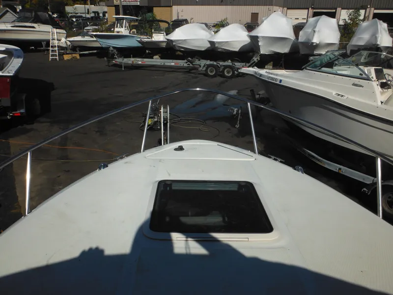 Slide: The Image of 2004 Sea Ray 215 Weekender boat in marina, surrounded by other vessels. - 16