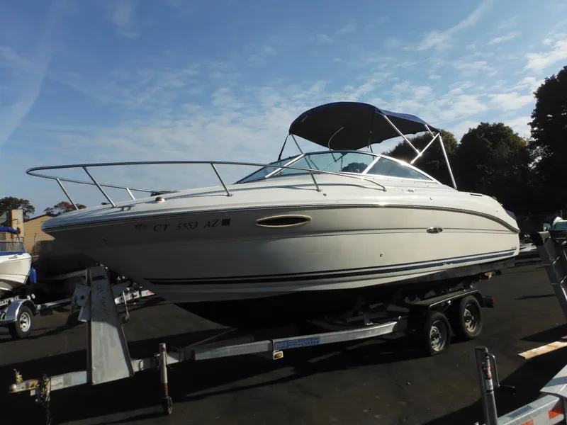 Slide: The Image of 2004 Sea Ray 215 Weekender boat on trailer under clear sky. - 22