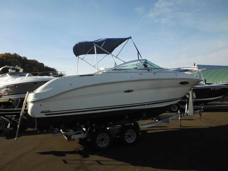 Slide: The Image of 2004 Sea Ray 215 Weekender boat on trailer with blue canopy. - 23