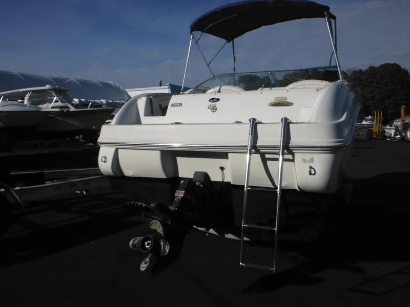 Slide: The Image of 2004 Sea Ray 215 Weekender boat with canopy and ladder, parked on a trailer. - 24