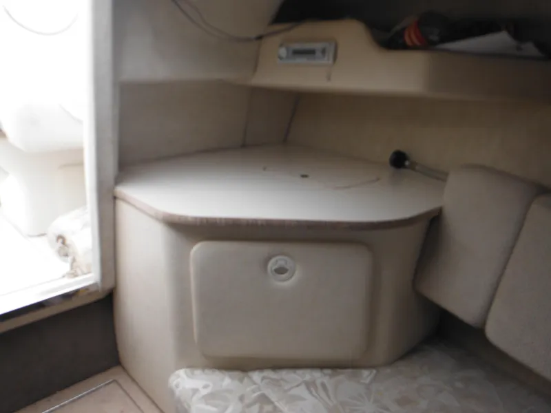 Slide: The Image of Interior cabin of 2004 Sea Ray 215 Weekender boat, featuring compact seating and storage. - 26