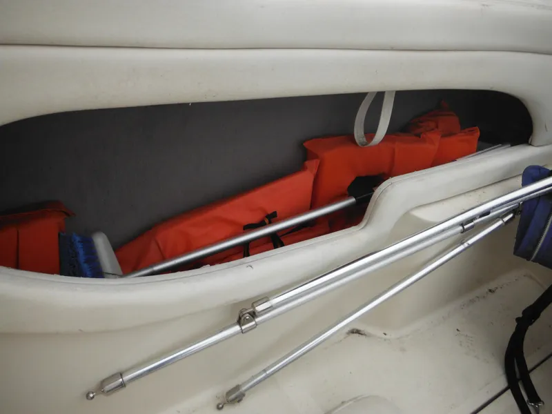 Slide: The Image of Storage compartment in a 2004 Sea Ray 215 Weekender with life jackets and equipment. - 42