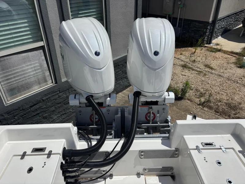 Slide: The Image of Twin outboard motors on a 2025 KenCraft 269 boat, parked near a building. - 10