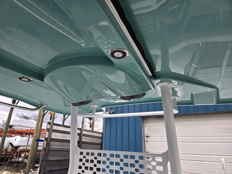 Slide: The Image of 2025 Hurricane Center Console 24 OB boat, teal interior, modern design, docked in marina. - 17