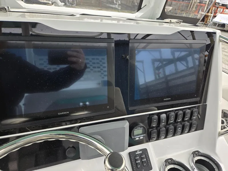 Slide: The Image of 2025 Hurricane Center Console 24 OB dashboard with dual Garmin displays and control panel. - 19