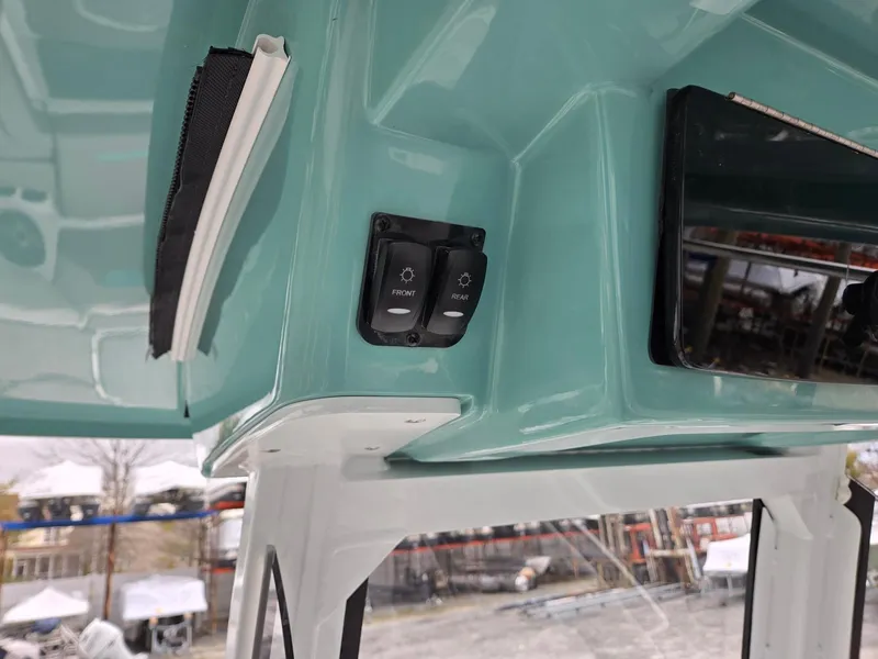 Slide: The Image of 2025 Hurricane Center Console 24 OB boat interior with control switches and teal finish. - 21