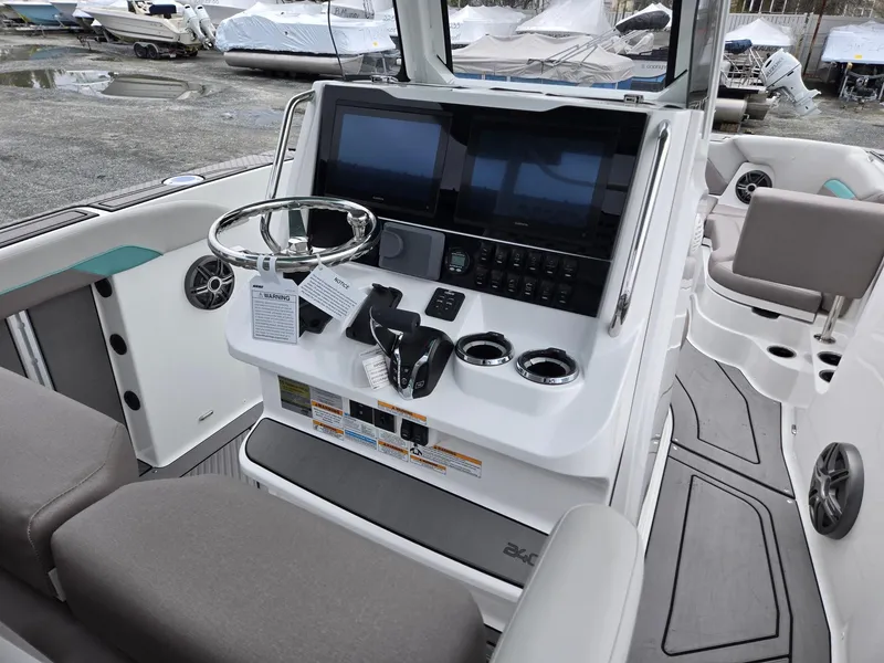 Slide: The Image of 2025 Hurricane Center Console 24 OB boat dashboard with steering wheel and controls. - 30