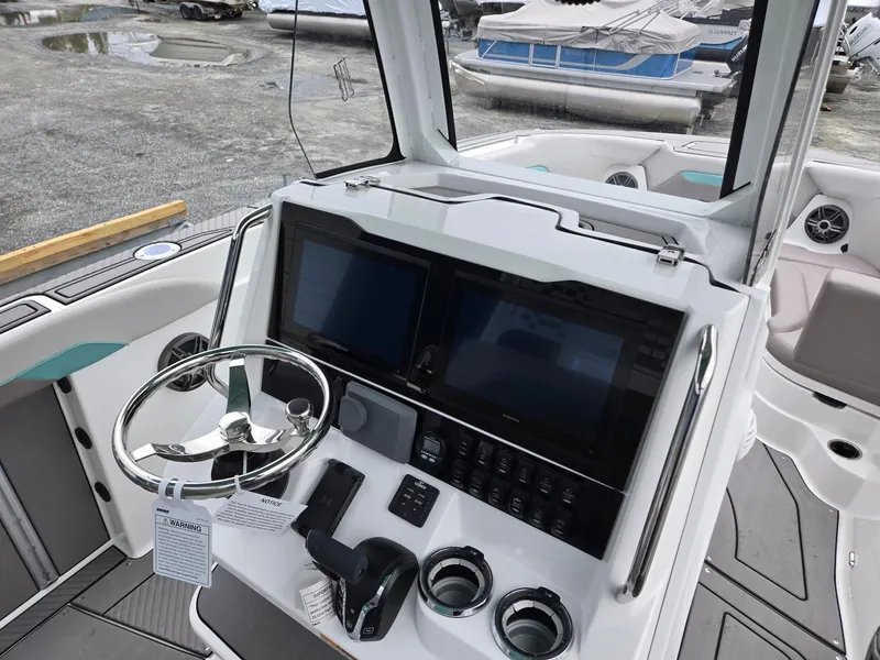 Slide: The Image of 2025 Hurricane Center Console 24 OB boat dashboard with dual screens and steering wheel. - 37