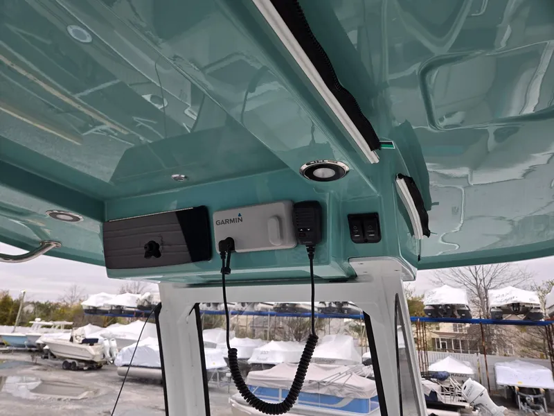 Slide: The Image of 2025 Hurricane Center Console 24 OB boat interior with electronic equipment and teal ceiling. - 38