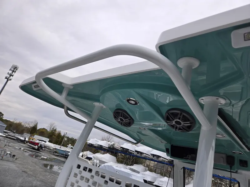 Slide: The Image of 2025 Hurricane Center Console 24 OB boat with teal canopy and speakers. - 39