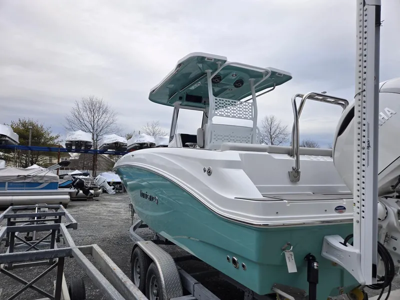 Slide: The Image of 2025 Hurricane Center Console 24 OB boat on trailer, parked outdoors. - 5