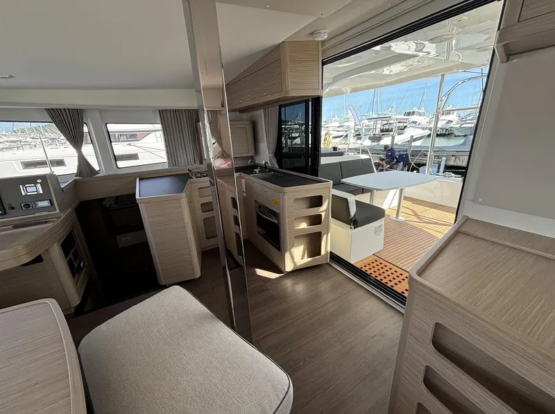 Slide: The Image of Interior of 2025 Lagoon 42 catamaran with modern furnishings and marina view. - 10