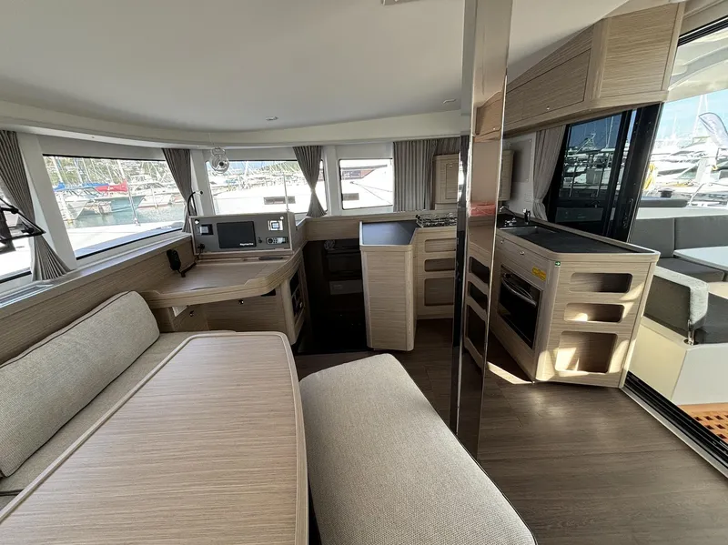 Slide: The Image of Modern interior of 2025 Lagoon 42 catamaran with spacious seating and kitchen area. - 11