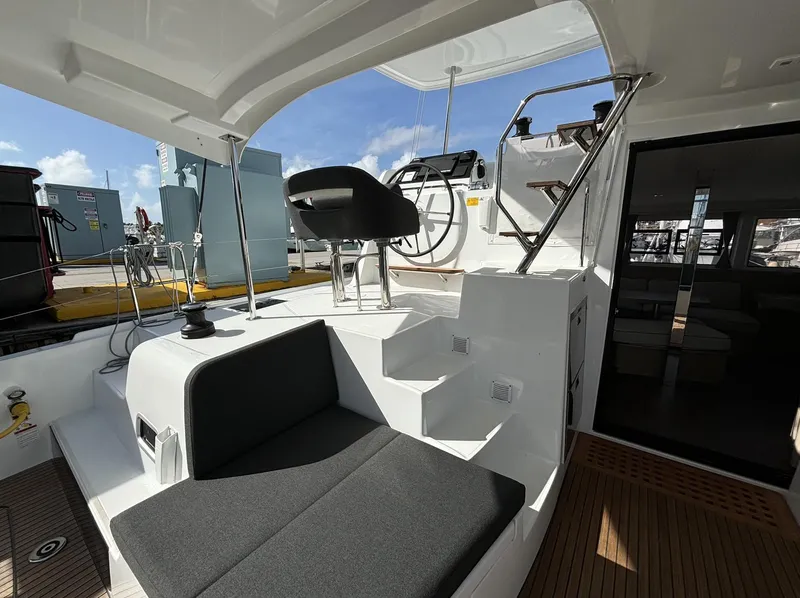 Slide: The Image of 2025 Lagoon 42 yacht cockpit with seating and helm station under sunny skies. - 16