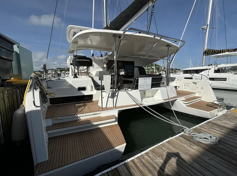Slide: The Image of 2025 Lagoon 42 catamaran docked at marina, featuring spacious deck and modern design. - 17
