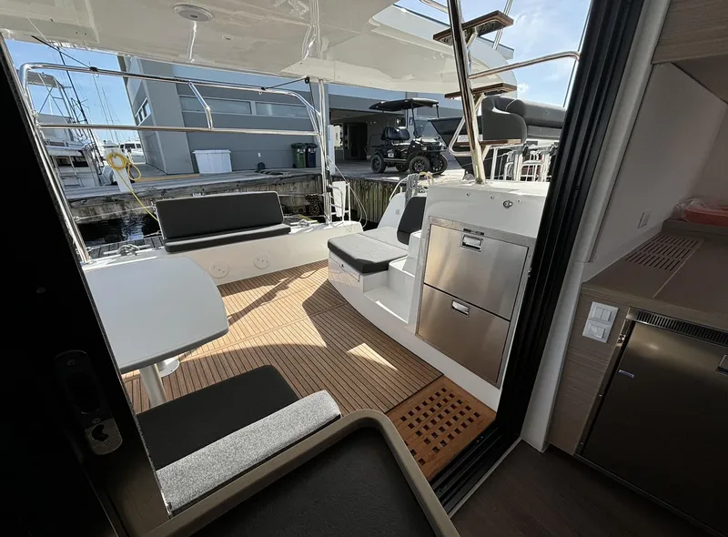 Slide: The Image of 2025 Lagoon 42 yacht cockpit with seating, table, and modern amenities. - 2